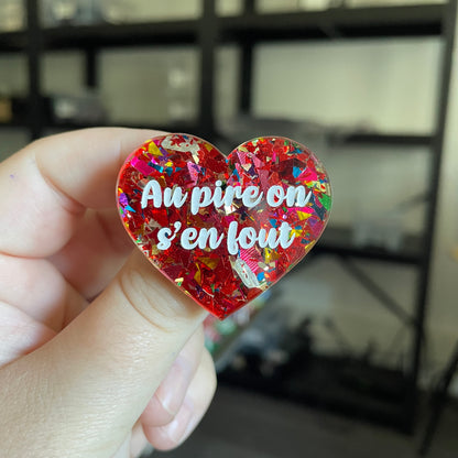 Broche "Au pire on s'en fout" en acrylique transparente avec des confettis rouges et multicolores