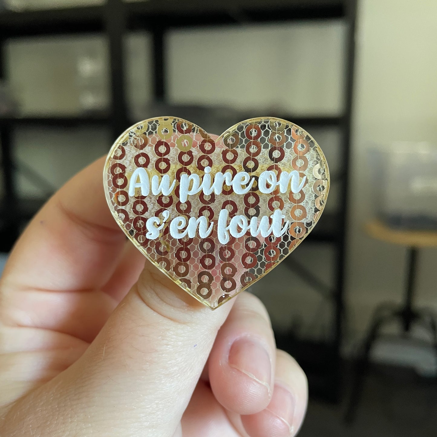 Broche "Au pire on s'en fout" en acrylique japonaise transparente avec des sequins dorés