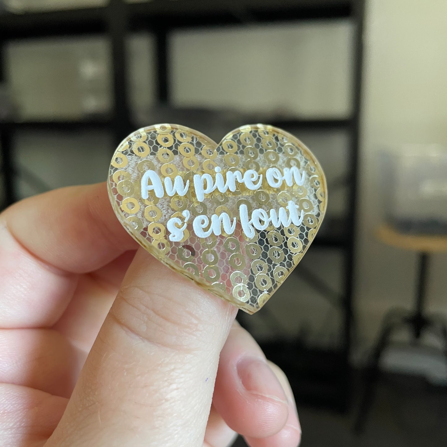 Broche "Au pire on s'en fout" en acrylique japonaise transparente avec des sequins dorés