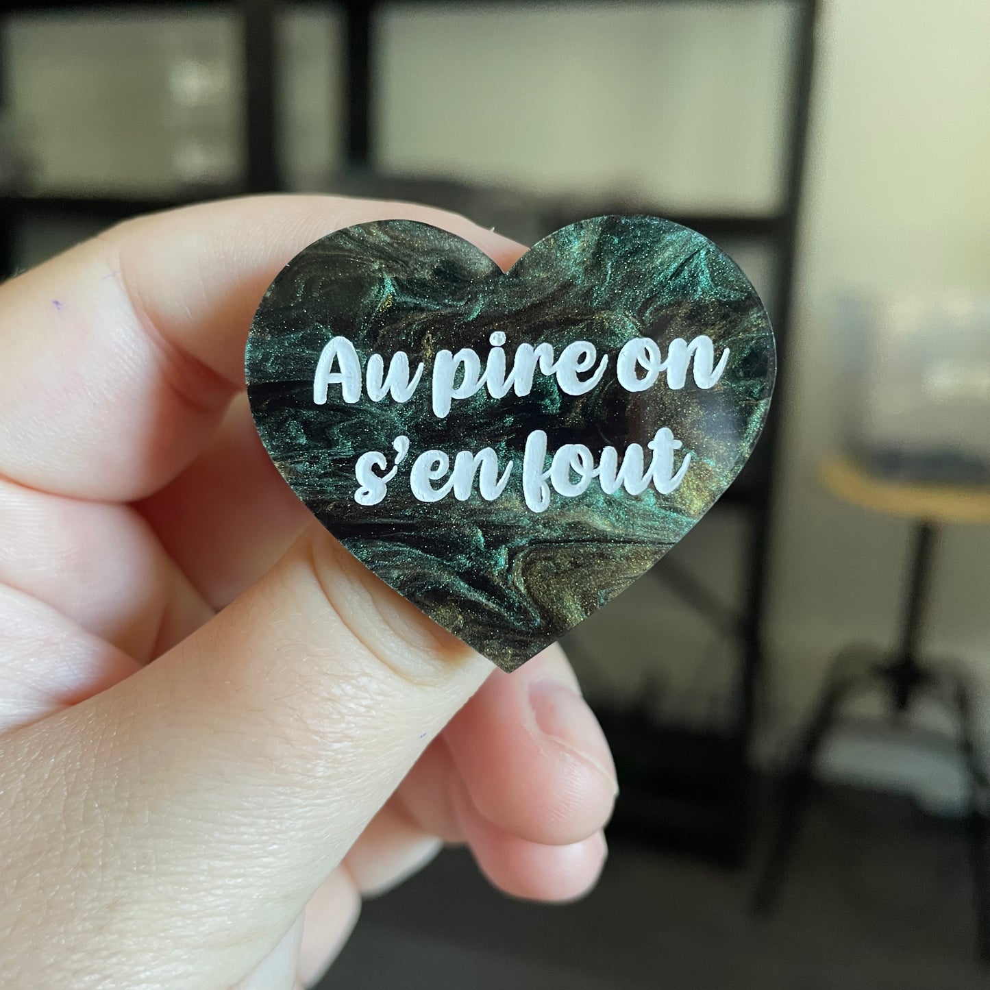Broche "Au pire on s'en fout" en acrylique marbrée noire, verte et dorée