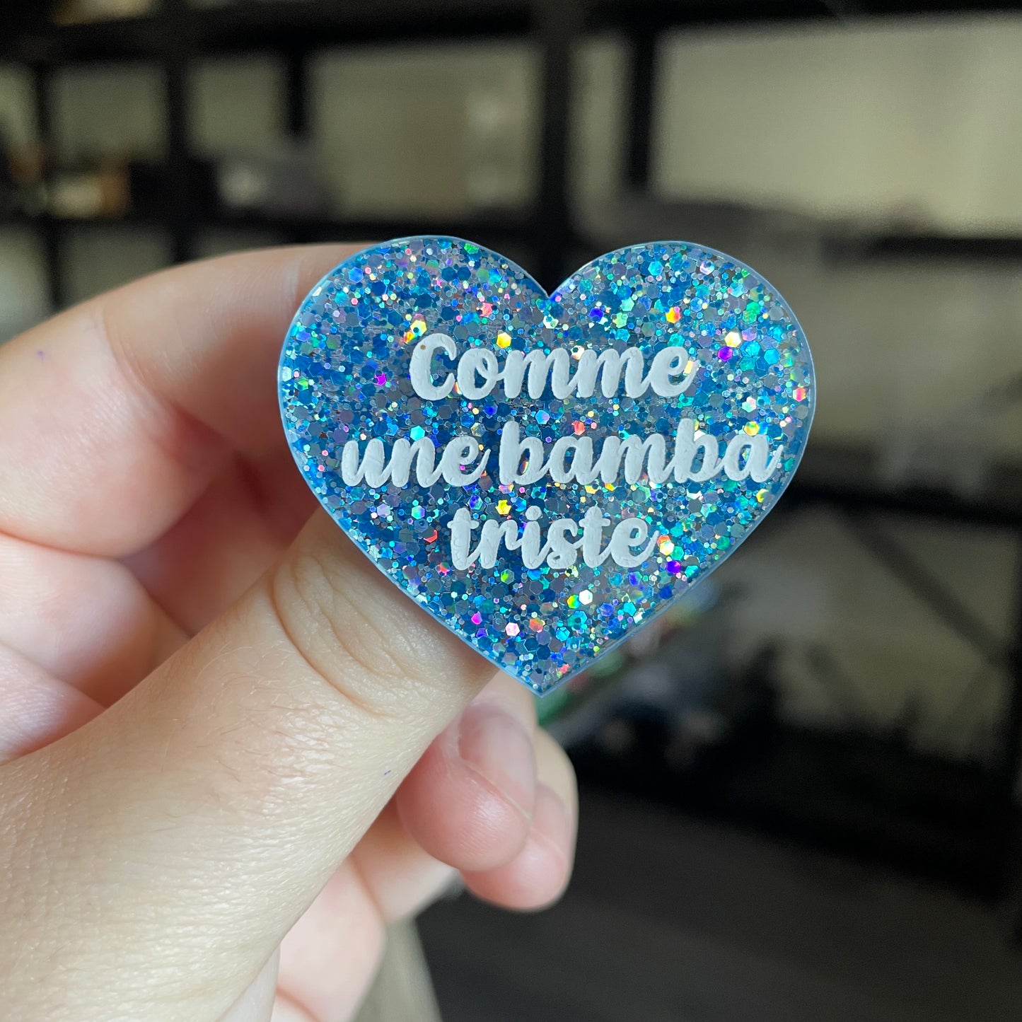 Broche "Comme une bamba triste" en acrylique semi transparente avec des confettis bleus et argentés