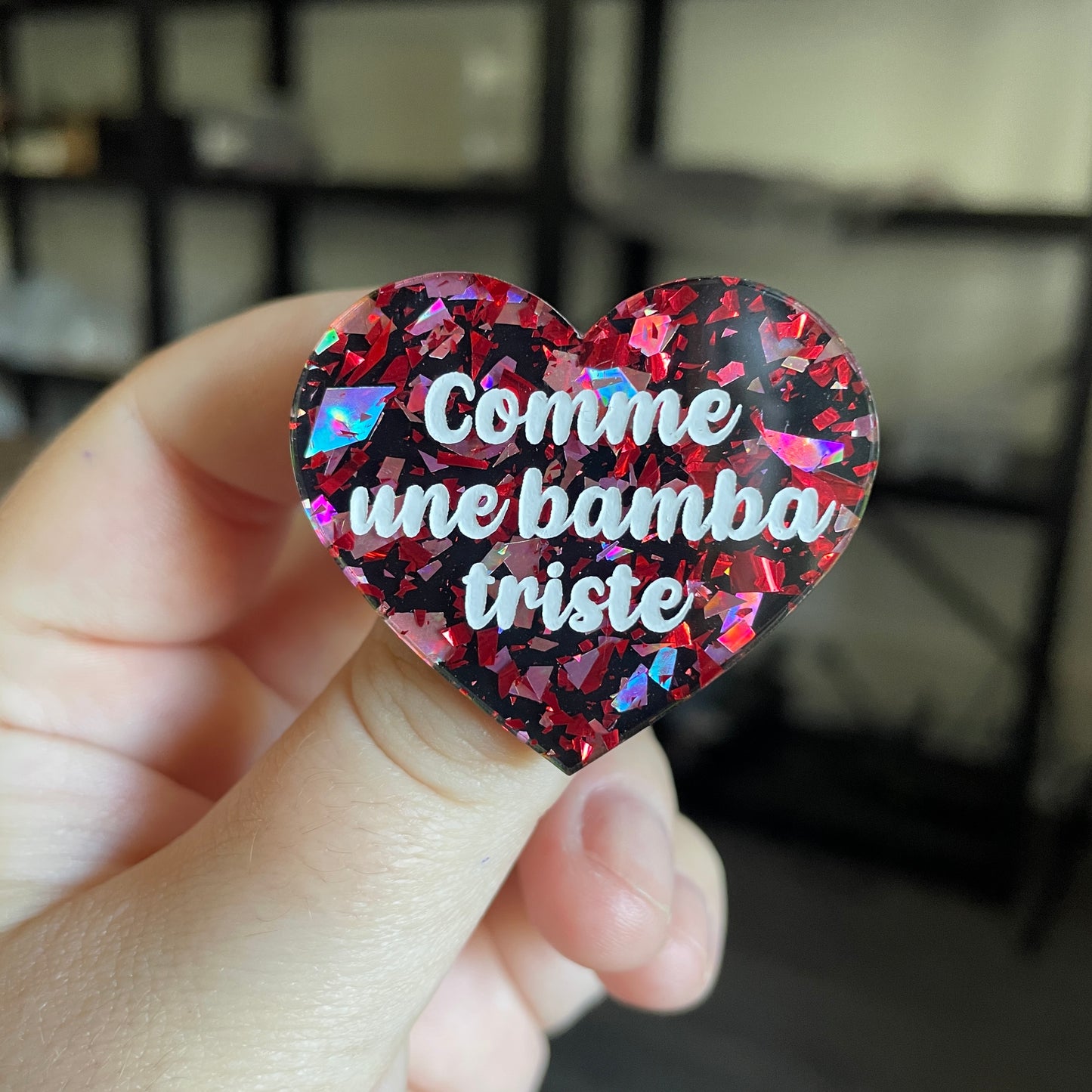 Broche "Comme une bamba triste" en acrylique noire avec des éclats de confettis rouges et roses