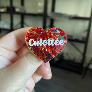 Broche "Culottée" en acrylique transparente avec des éclats de confettis rouges et multicolores