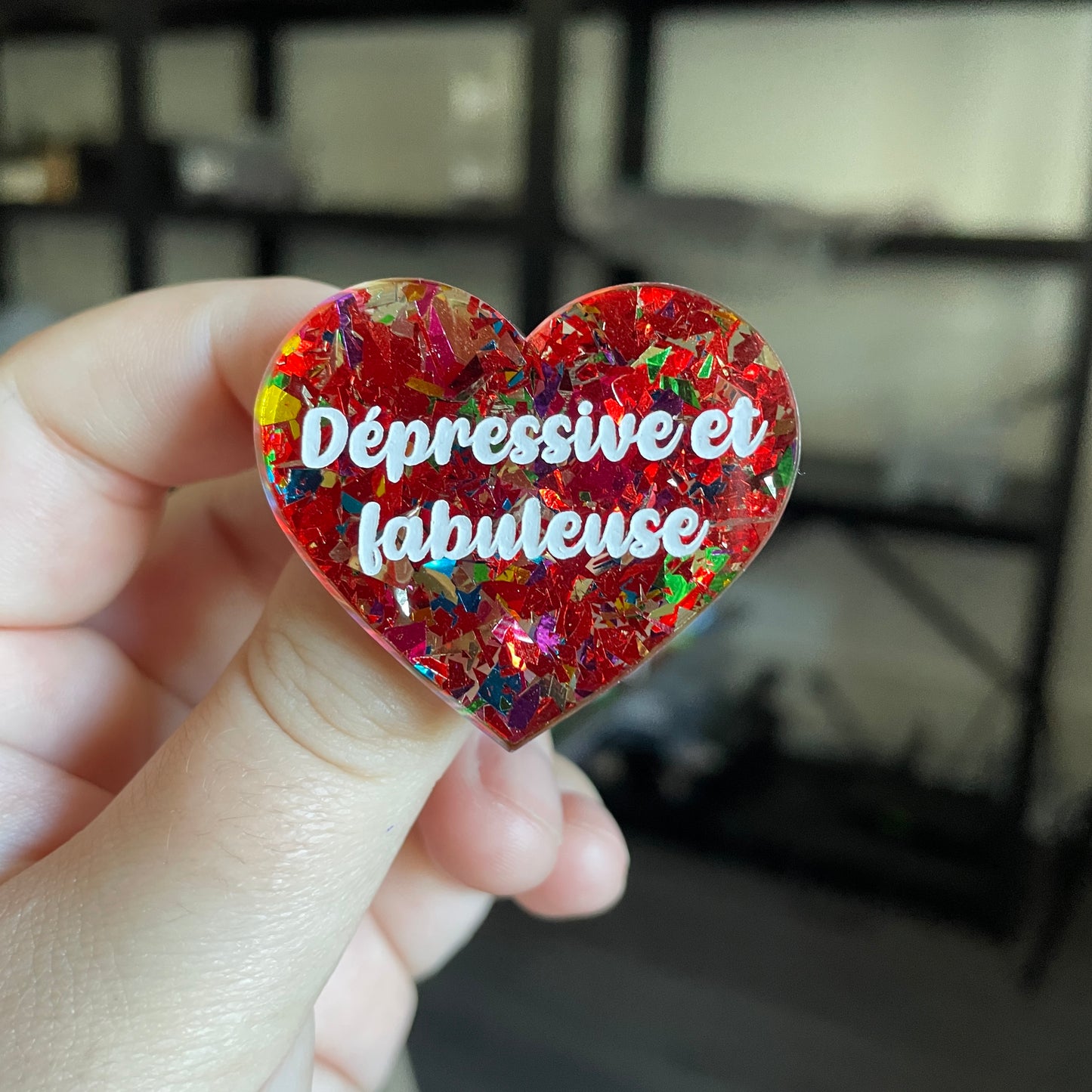 Broche "Dépressive et fabuleuse" en acrylique transparente avec des éclats de confettis rouges et multicolores