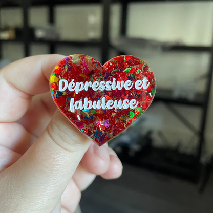 Broche "Dépressive et fabuleuse" en acrylique transparente avec des éclats de confettis rouges et multicolores
