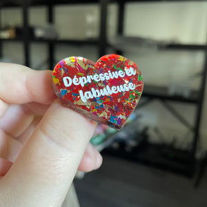 Broche "Dépressive et fabuleuse" en acrylique transparente avec des éclats de confettis rouges et multicolores