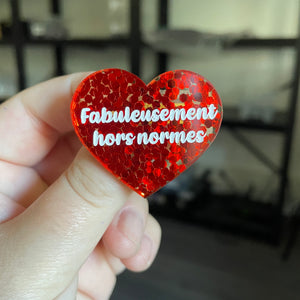 Broche "Fabuleusement hors normes" en acrylique semi transparente avec des confettis rouges