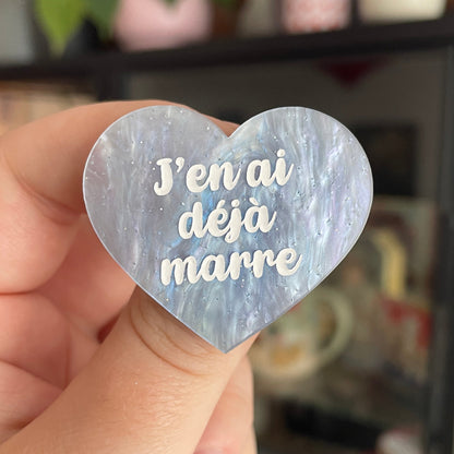 Broche "J'en ai déjà marre" en acrylique marbrée nacrée blanche et bleutée à paillettes