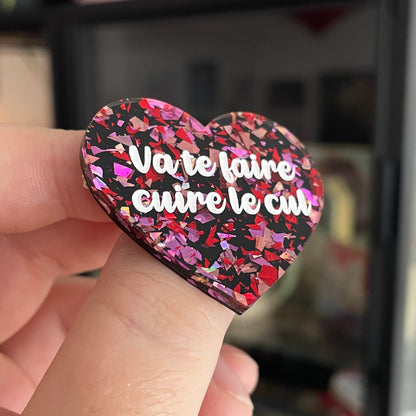 Broche "Va te faire cuire le cul" en acrylique noire avec des confettis rouges et roses
