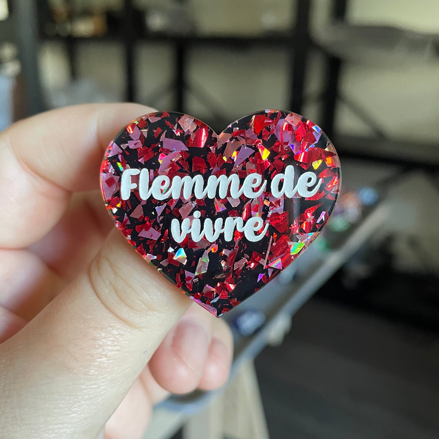 Broche "Flemme de vivre" en acrylique noire avec des éclats de confettis rouges et roses