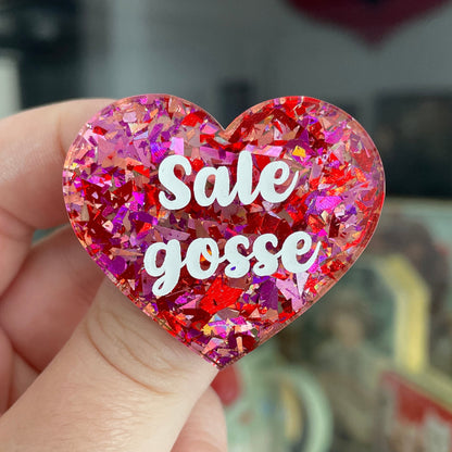 Broche "Sale gosse" en acrylique transparente avec des confettis rouges et roses