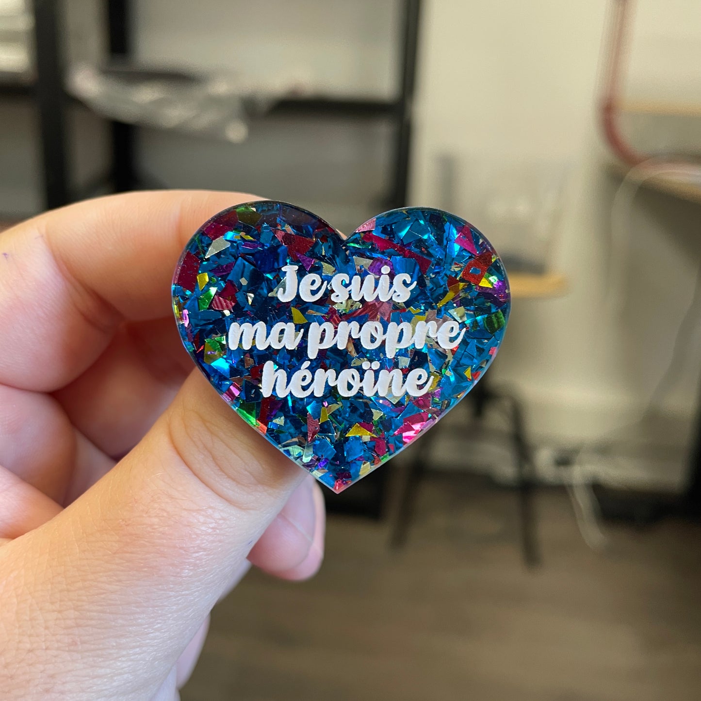 Broche "Je suis ma propre héroïne" en acrylique transparente avec des éclats de confettis bleus et multicolores