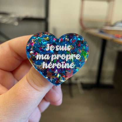 Broche "Je suis ma propre héroïne" en acrylique transparente avec des éclats de confettis bleus et multicolores