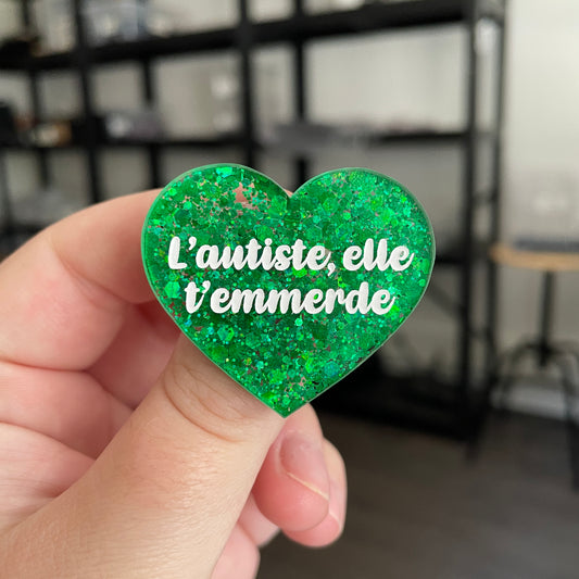 Broche "L'autiste, elle t'emmerde" en acrylique semi transparente à paillettes vertes