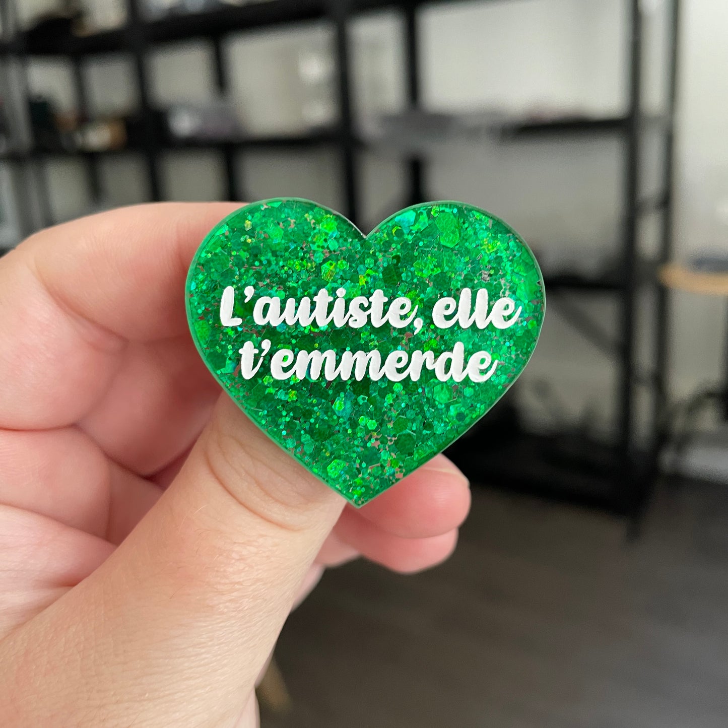 Broche "L'autiste, elle t'emmerde" en acrylique semi transparente à paillettes vertes
