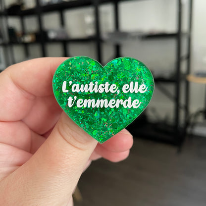 Broche "L'autiste, elle t'emmerde" en acrylique semi transparente à paillettes vertes