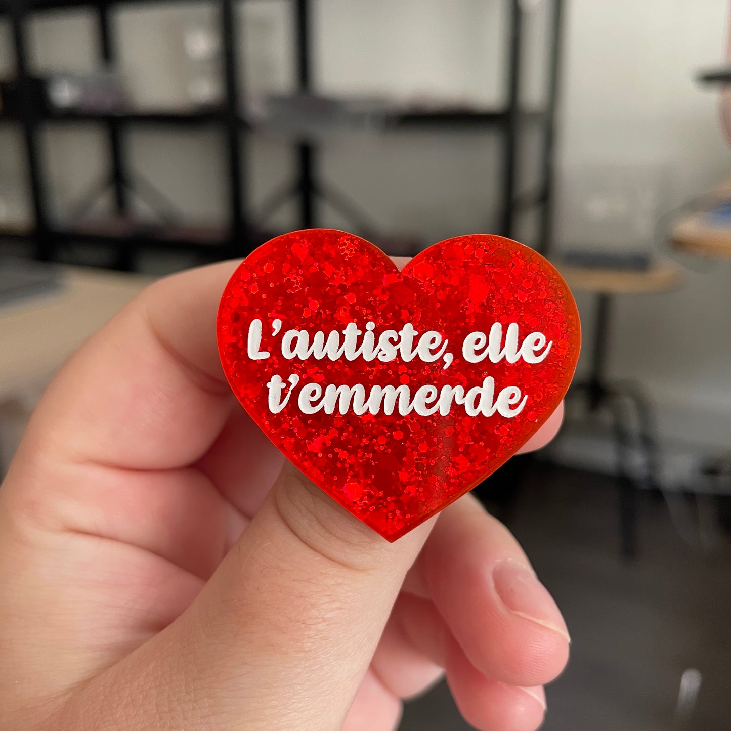 Broche "L'autiste, elle t'emmerde" en acrylique à paillettes oranges