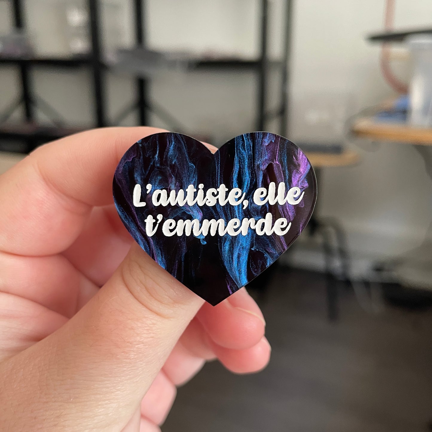 Broche "L'autiste, elle t'emmerde" en acrylique marbrée noire, bleue et violette (à dominante noire)