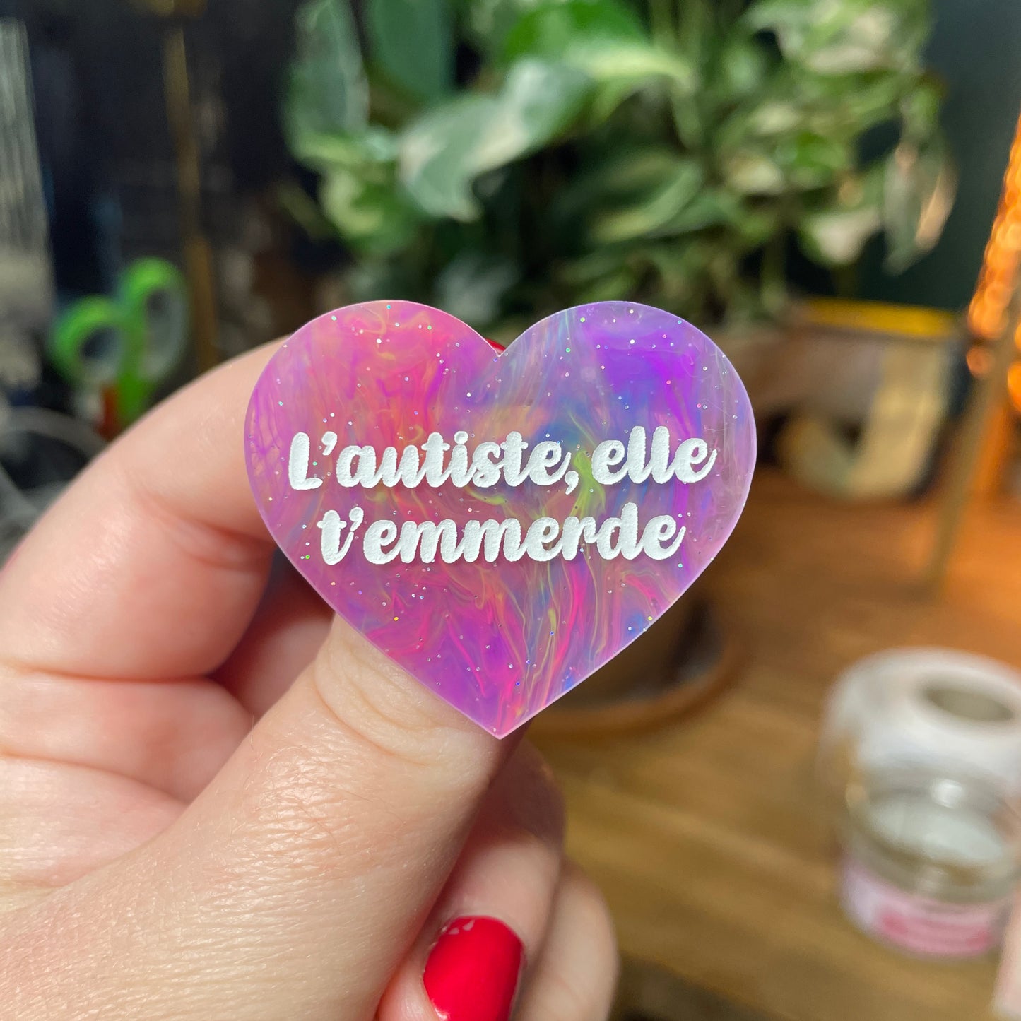 Broche "L'autiste, elle t'emmerde" en acrylique semi transparente marbrée multicolore
