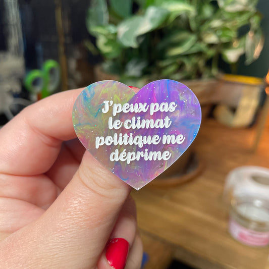 Broche "J'peux pas le climat politique me déprime" en acrylique semi transparente marbrée multicolore