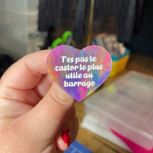 Broche "T'es pas le castor le plus utile au barrage" en acrylique semi transparente marbrée multicolore