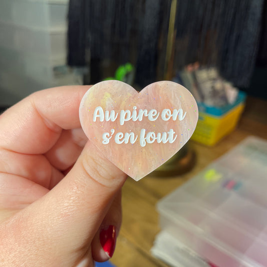 Broche "Au pire on s'en fout" en acrylique semi transparente marbrée corail, orange et jaune à paillettes