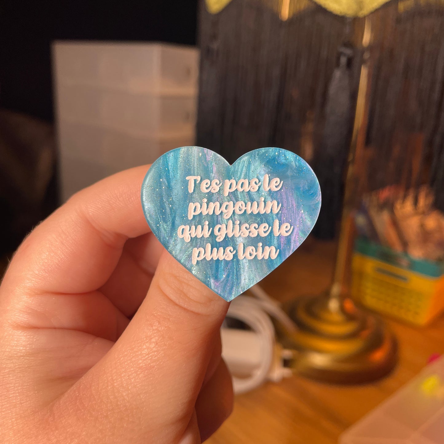 Broche "T'es pas le pingouin qui glisse le plus loin" en acrylique marbrée bleue à paillettes