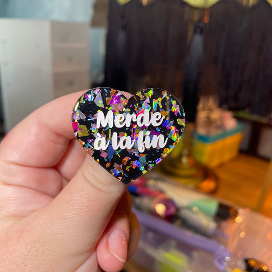 Broche "Merde à la fin" en acrylique noire avec des éclats de confettis multicolores