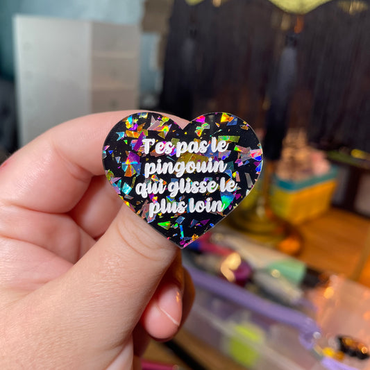 Broche "T'es pas le pingouin qui glisse le plus loin" en acrylique noire avec des éclats de confettis multicolores