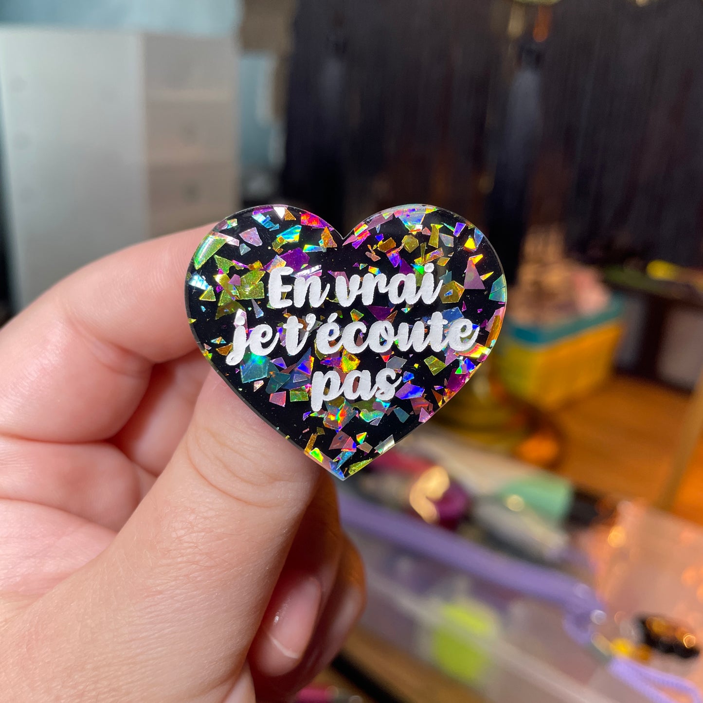 Broche "En vrai je t'écoute pas" en acrylique noire avec des éclats de confettis multicolores