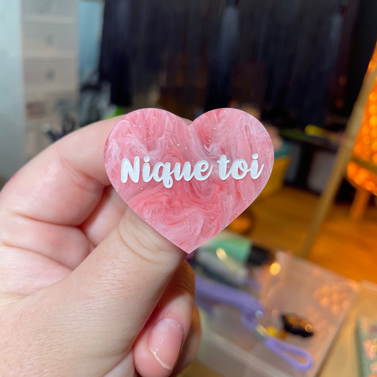 Broche "Nique toi" en acrylique semi transparente marbrée rose et blanche à paillettes