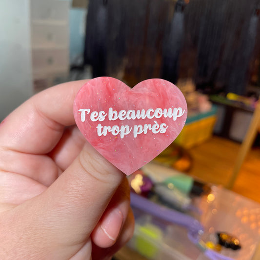 Broche "T'es beaucoup trop près" en acrylique semi transparente marbrée rose et blanche à paillettes