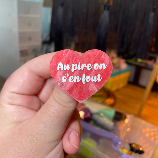 Broche "Au pire on s'en fout" en acrylique semi transparente marbrée rose et blanche à paillettes