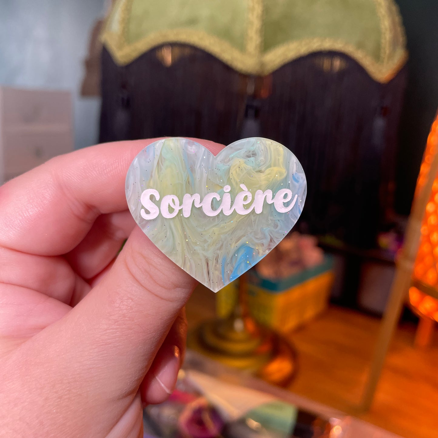 Broche "Sorcière" en acrylique semi transparente marbrée bleue, jaune et blanche à paillettes