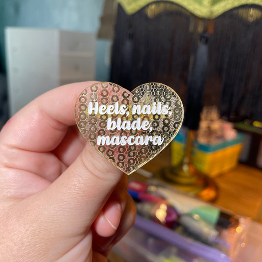 Broche "Heels, nails, blade, mascara" en acrylique japonaise transparente avec des sequins dorés