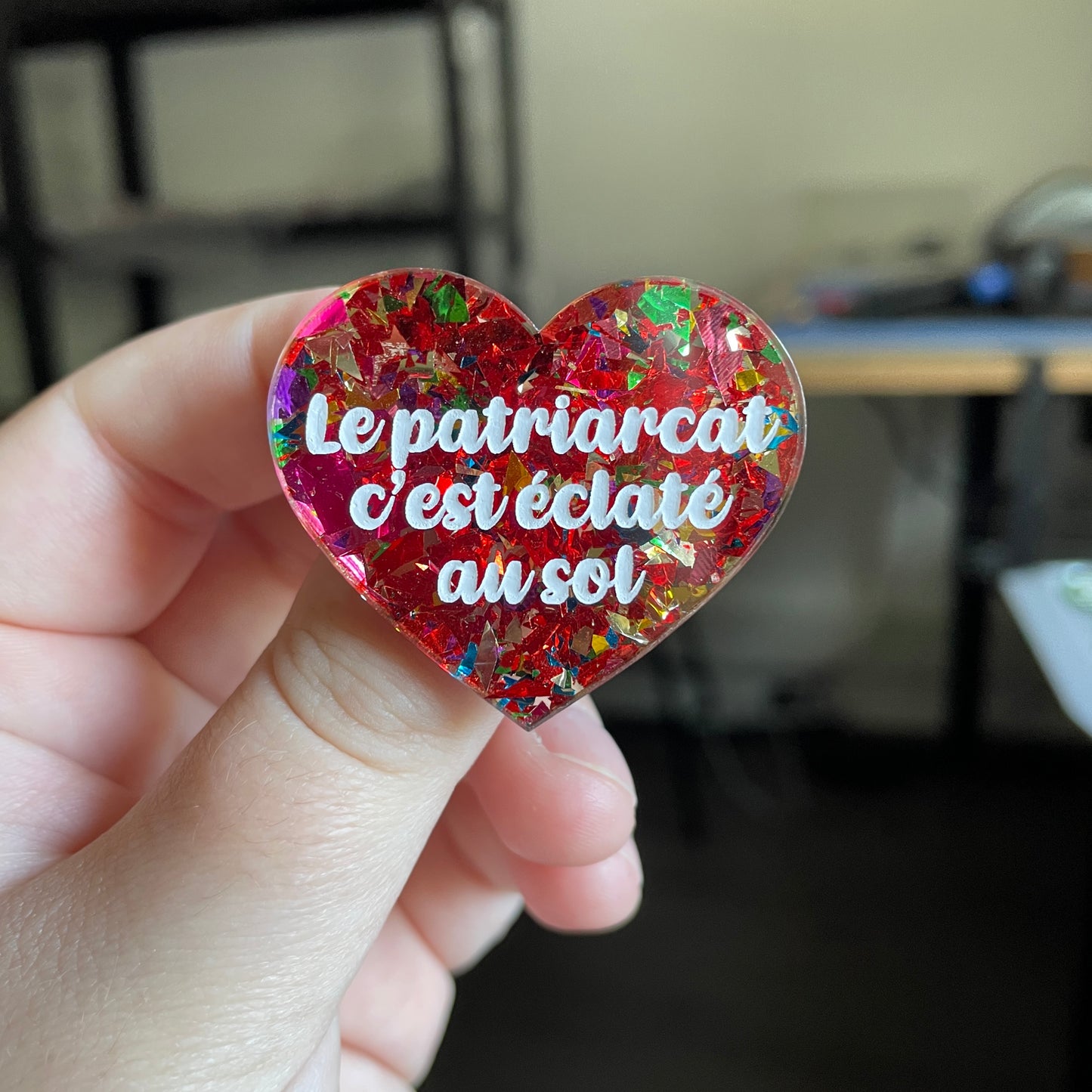 [CONTRÔLE TECHNIQUE] Broche "Le patriarcat c'est éclaté au sol" en acrylique transparente avec des éclats de confettis rouges et multicolores