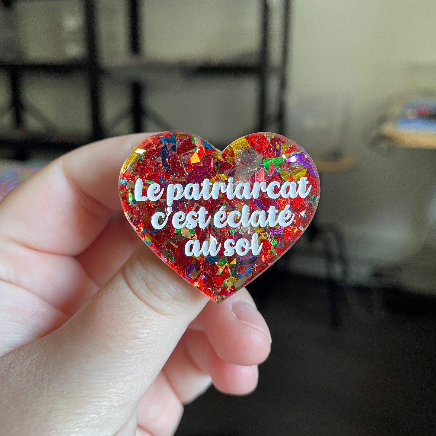 [CONTRÔLE TECHNIQUE] Broche "Le patriarcat c'est éclaté au sol" en acrylique transparente avec des éclats de confettis rouges et multicolores