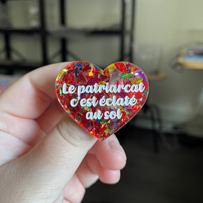 [CONTRÔLE TECHNIQUE] Broche "Le patriarcat c'est éclaté au sol" en acrylique transparente avec des éclats de confettis rouges et multicolores