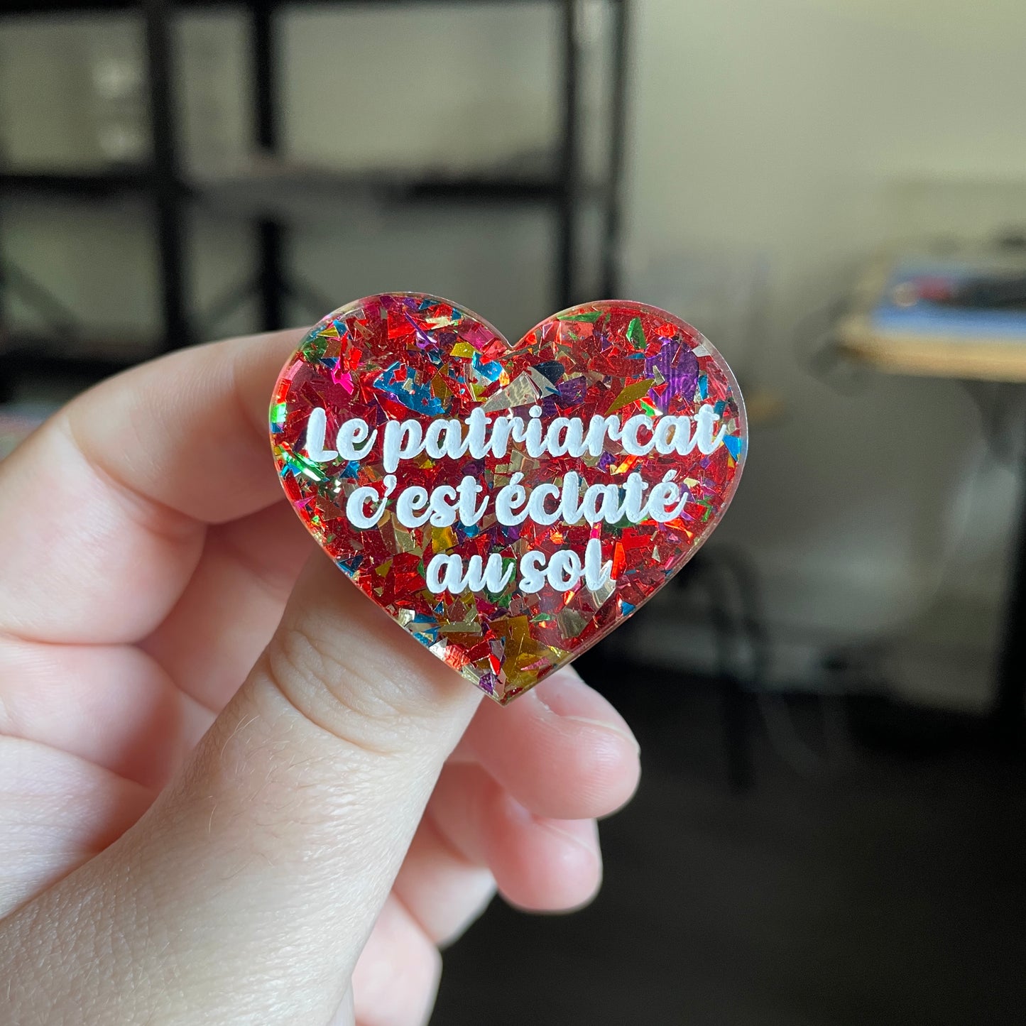 [CONTRÔLE TECHNIQUE] Broche "Le patriarcat c'est éclaté au sol" en acrylique transparente avec des éclats de confettis rouges et multicolores