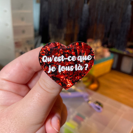 [Contrôle technique] Broche "Qu'est-ce que je fous là ?" en acrylique noire avec des éclats de confettis rouges