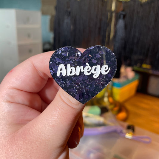 [Contrôle technique] Broche "Abrège" en acrylique noire avec des éclats de confettis gris