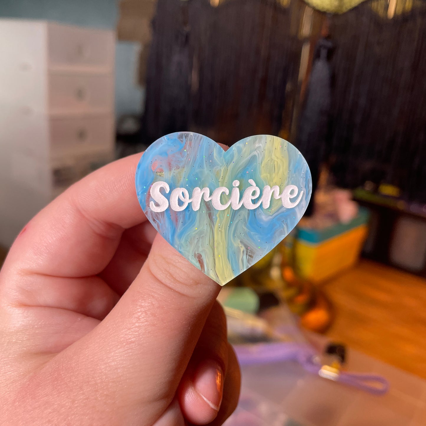 [Contrôle technique] Broche "Sorcière" en acrylique semi transparente marbrée bleue, blanche et jaune à paillettes