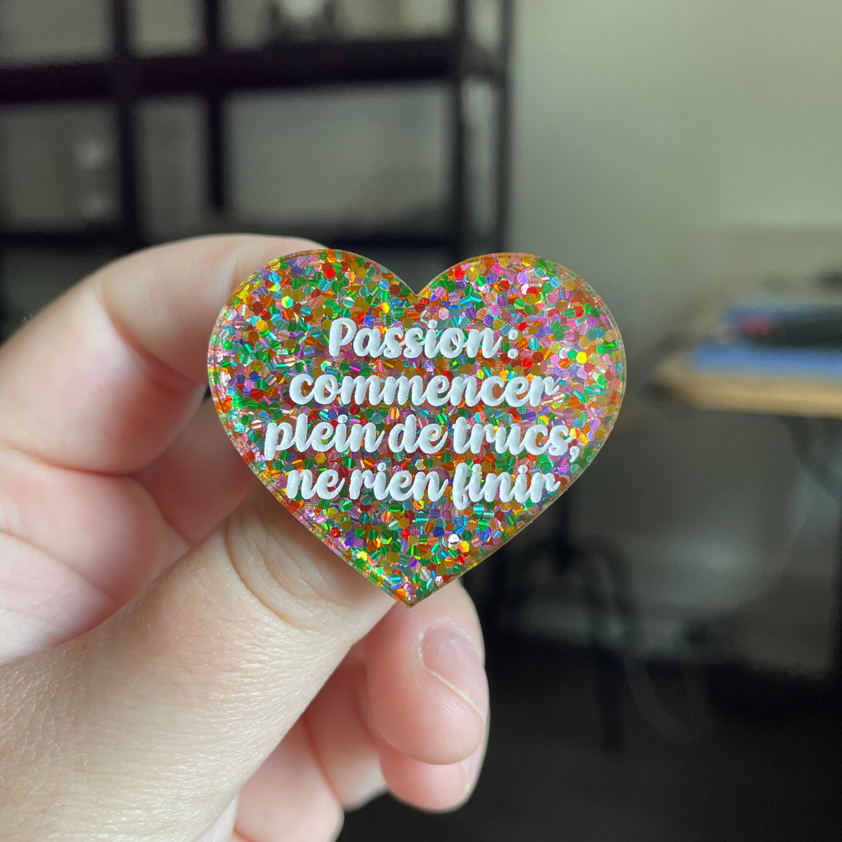 [CONTRÔLE TECHNIQUE] Broche "Passion : commencer plein de trucs, ne rien finir" en acrylique semi transparente avec des paillettes multicolores