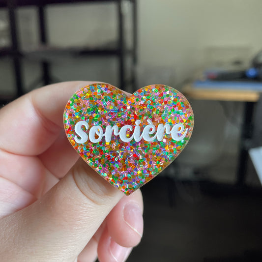 [CONTRÔLE TECHNIQUE] Broche "Sorcière" en acrylique semi transparente avec des paillettes multicolores