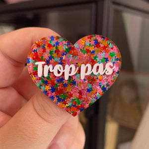 Broche "Trop pas" en acrylique semi-transparente avec des confettis étoiles multicolores