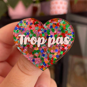 Broche "Trop pas" en acrylique semi-transparente avec des confettis étoiles multicolores