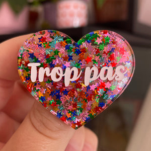 Broche "Trop pas" en acrylique semi-transparente avec des confettis étoiles multicolores