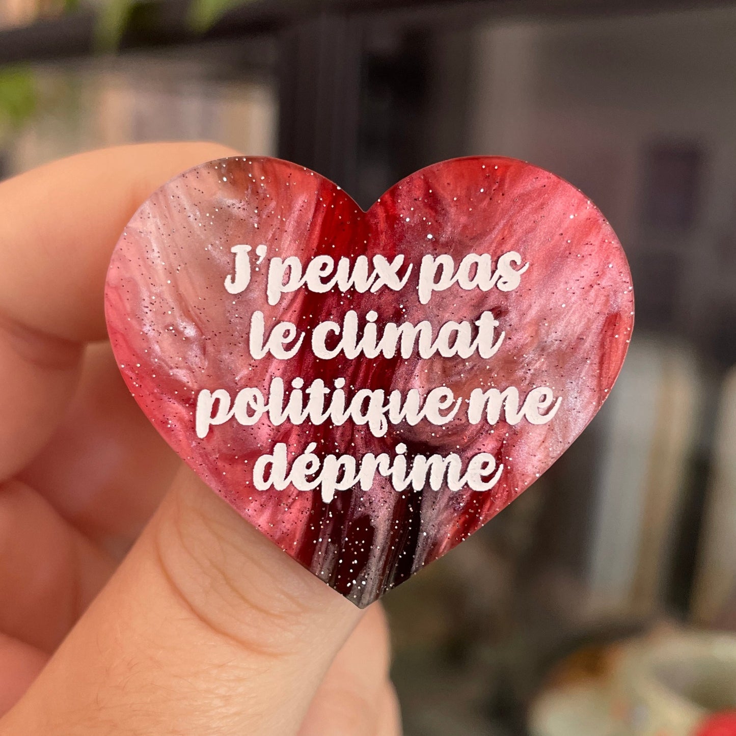 Broche "J'peux pas le climat politique me déprime" en acrylique marbrée rouge, marron, verte et blanche