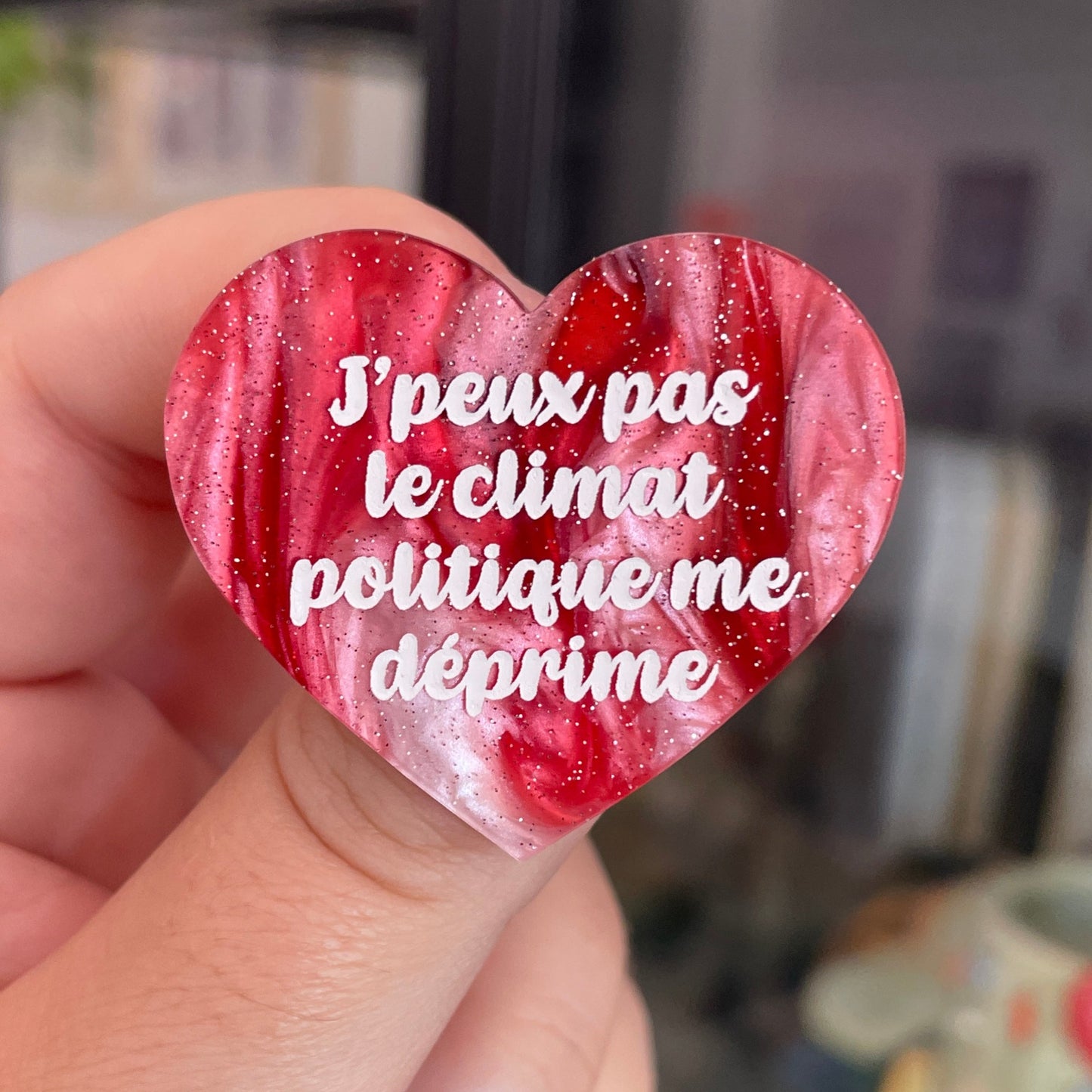 Broche "J'peux pas le climat politique me déprime" en acrylique marbrée rouge, marron, verte et blanche