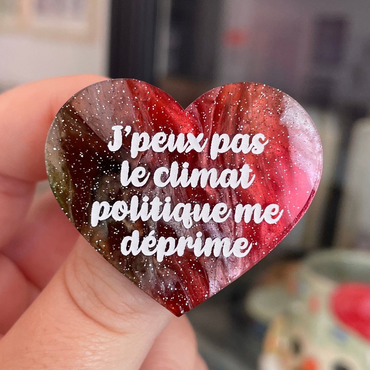 Broche "J'peux pas le climat politique me déprime" en acrylique marbrée rouge, marron, verte et blanche